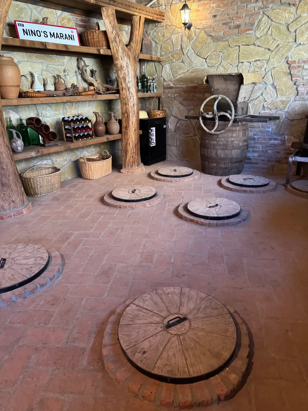 Interno di un marani con i coperchi di legno dei qvevri interrati nel pavimento
